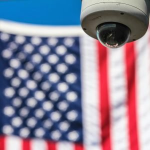 Surveillance camera focusing on security with American flag backdrop.